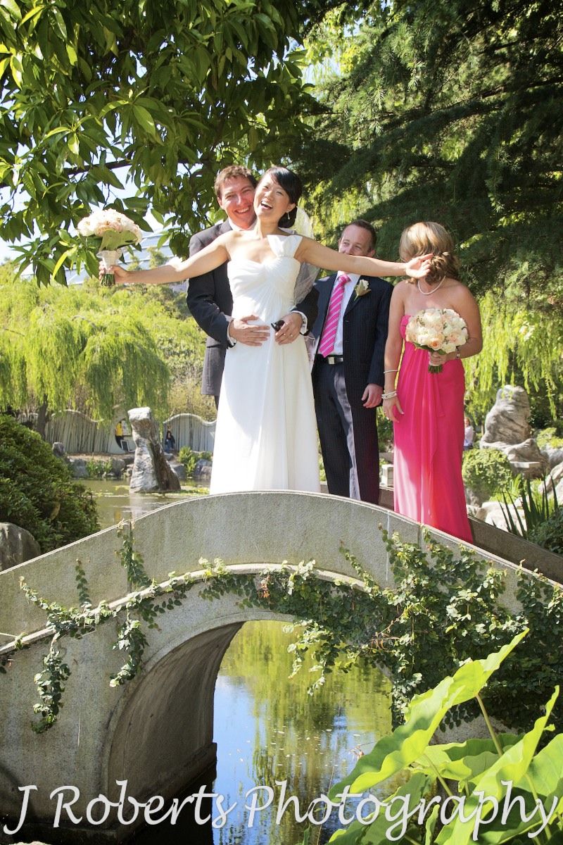 Groom holding bride on bridge at chinese gardens sydney - wedding photography sydney